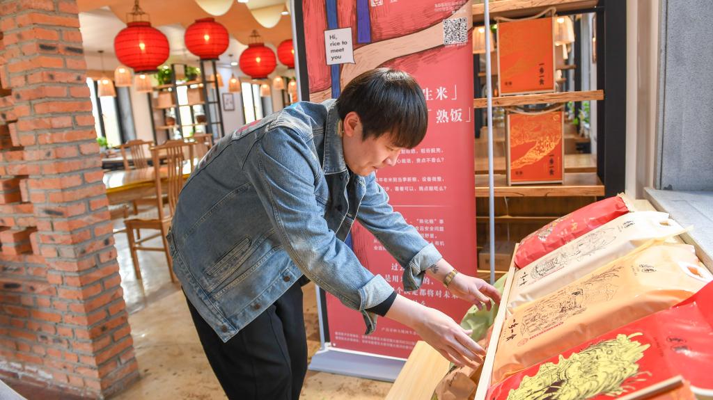 2021年4月20日，在吉林市船营区大绥河镇，创业者曹曦将农场生产的大米摆在民宿显眼位置进行展示。